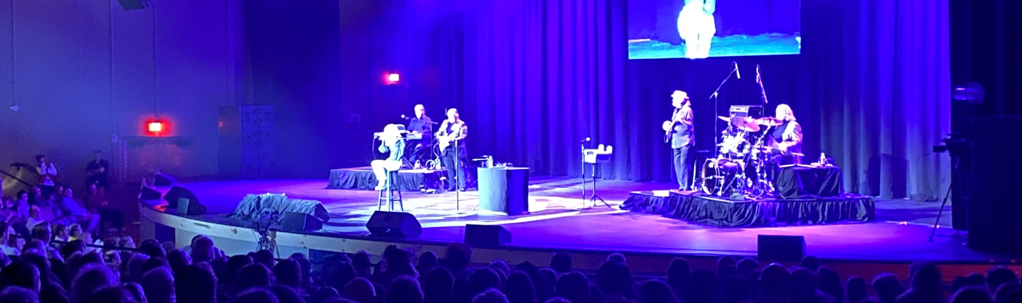 signer on stage in chair washed out by the lights Jacksonville